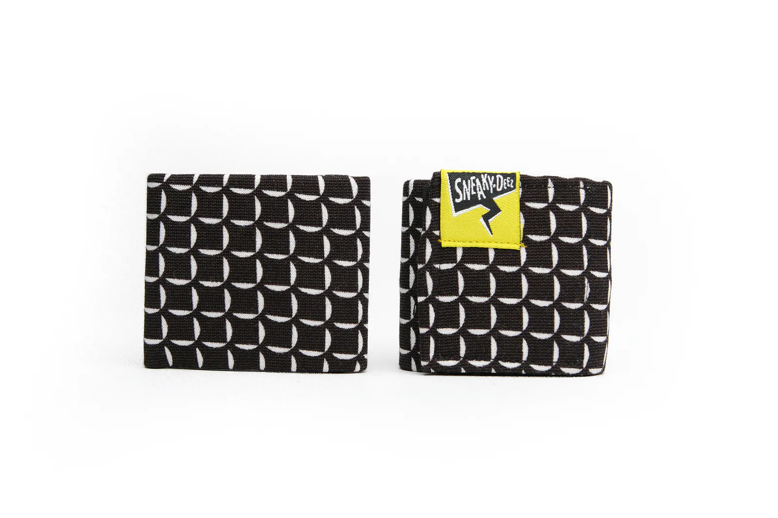 A pair of black SneakyDeez wrist wraps with a white crescent grid print, folded neatly and standing on a white background